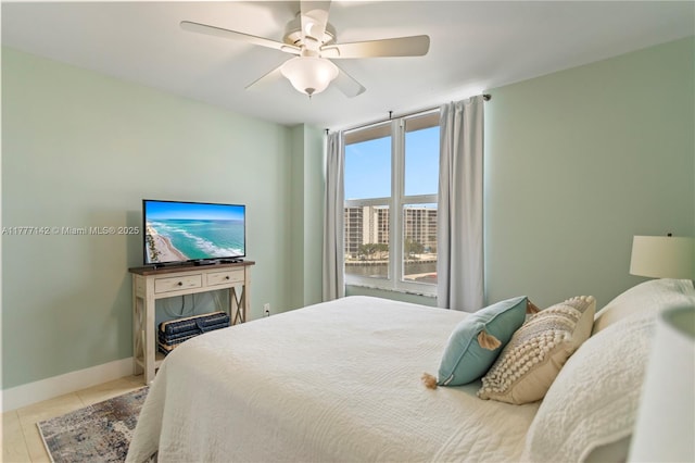 tiled bedroom with baseboards and a ceiling fan