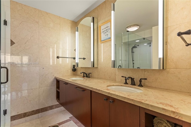 full bath with a stall shower, double vanity, a sink, and tile walls