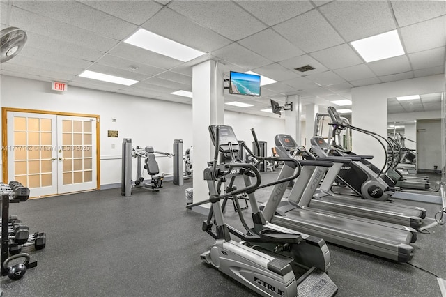 gym featuring a paneled ceiling, french doors, baseboards, and visible vents