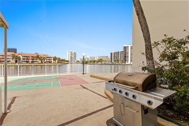 view of patio / terrace featuring a city view, grilling area, and shuffleboard