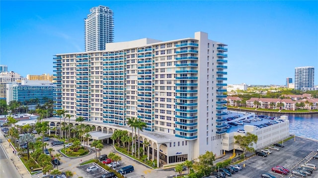view of building exterior featuring a water view and a city view