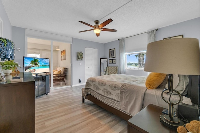14773 Cumberland Dr Unit 208, Delray Beach, FL 33446 - bedroom featuring light wood-style flooring, a textured ceiling, a ceiling fan, and baseboards