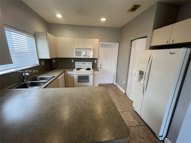 kitchen with backsplash, a sink, light tile patterned floors, white appliances, and visible vents