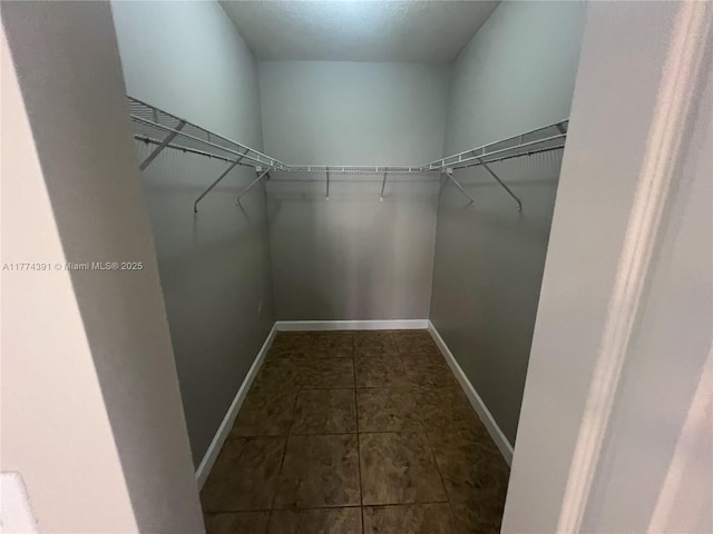 spacious closet with dark tile patterned flooring