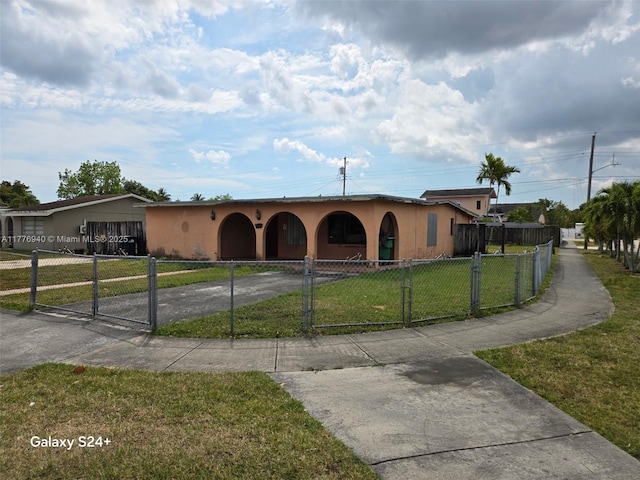 view of front of property with stucco siding, a fenced front yard, concrete driveway, and a front yard