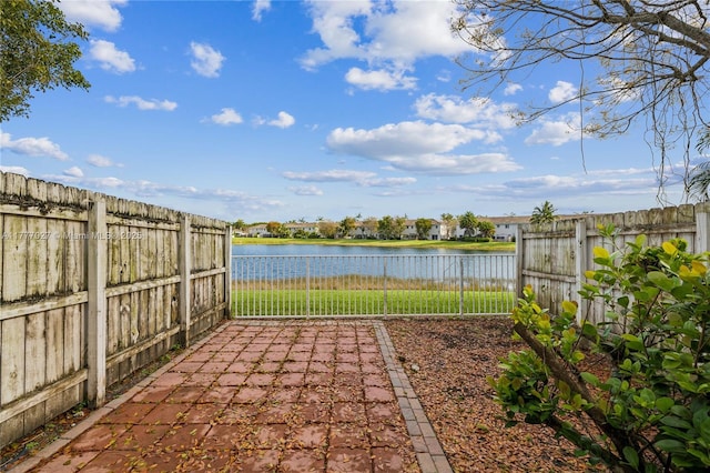 view of patio featuring a water view and a fenced backyard