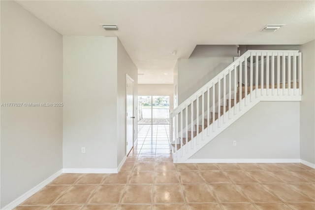 interior space featuring baseboards, tile patterned flooring, and visible vents