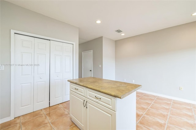 kitchen featuring light tile patterned floors, white cabinets, recessed lighting, a center island, and light countertops