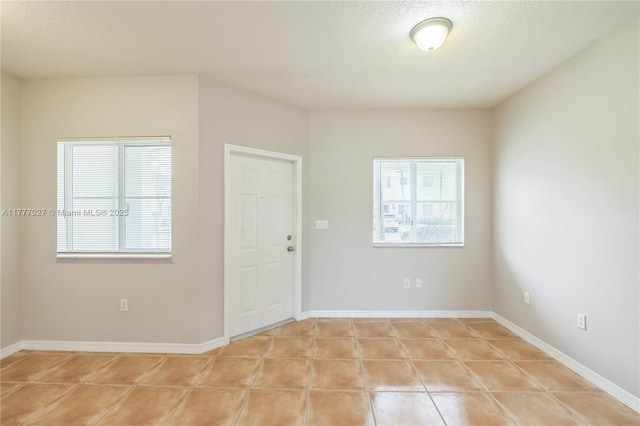 interior space featuring light tile patterned floors and baseboards