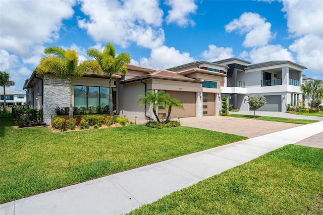 view of front of home with stucco siding, a front lawn, and decorative driveway