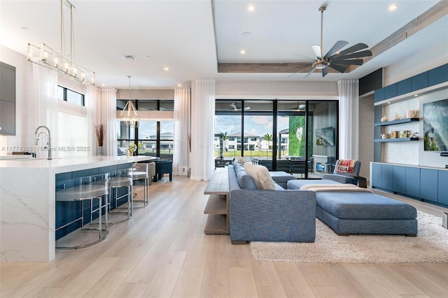 living room with ceiling fan, visible vents, recessed lighting, and light wood finished floors
