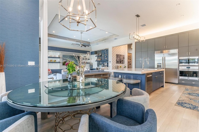 dining room featuring a tray ceiling, recessed lighting, a chandelier, light wood-style floors, and visible vents