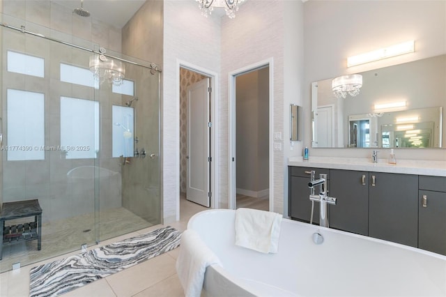 full bathroom featuring an inviting chandelier, tile patterned flooring, a freestanding tub, and a shower stall