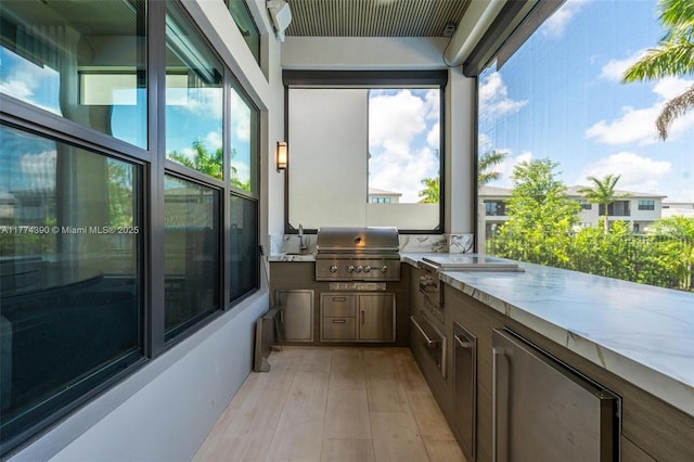 view of patio featuring grilling area, a sink, and exterior kitchen