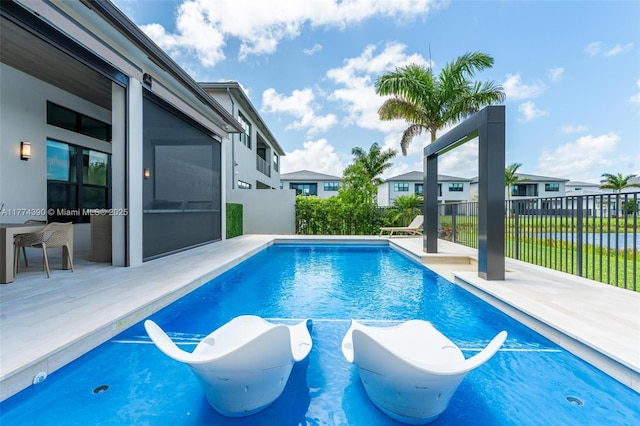 view of pool featuring a patio area, a residential view, fence, and a fenced in pool
