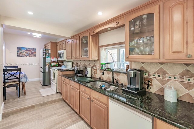 6250 SW 19th St, Miami, FL 33155 - kitchen featuring white appliances, baseboards, dark stone counters, a sink, and light wood-style flooring