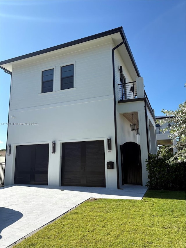 371 E Lakewood Rd, West Palm Beach, FL 33405 - contemporary home featuring a balcony, a garage, a front yard, concrete driveway, and stucco siding