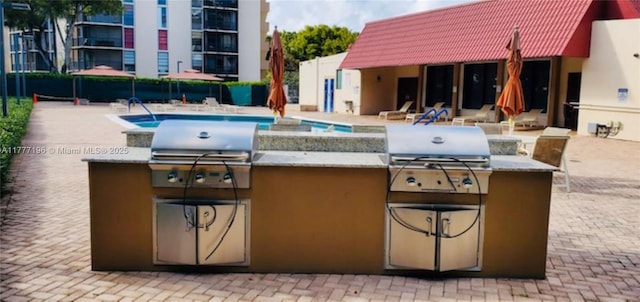 3301 N Country Club Dr Unit 612, Aventura, FL 33180 - view of patio featuring a grill, a community pool, and an outdoor kitchen