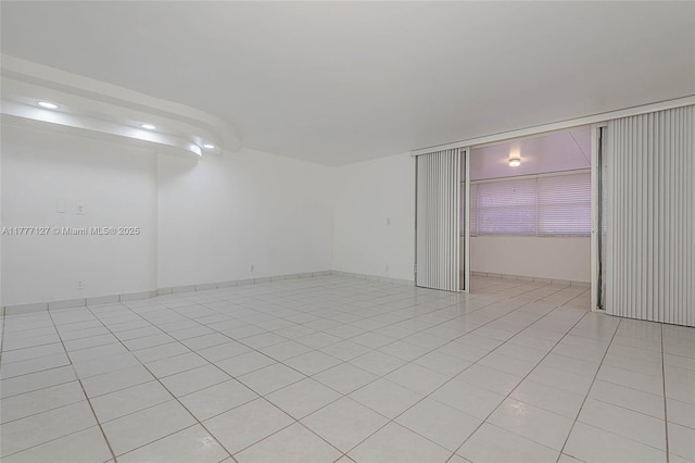 unfurnished room with recessed lighting and light tile patterned floors