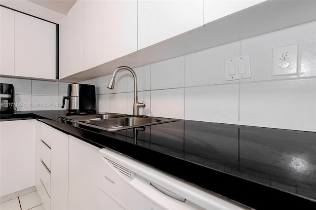 kitchen with a sink, dark countertops, decorative backsplash, and white cabinets
