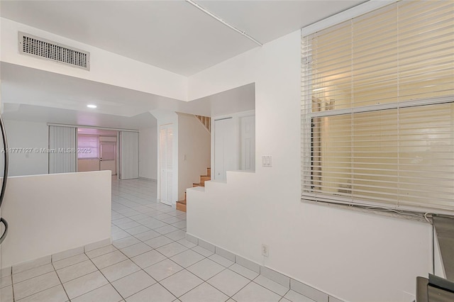 hallway with tile patterned flooring, stairs, and visible vents