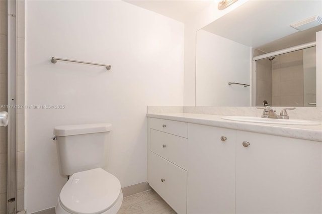 full bathroom featuring vanity, toilet, marble finish floor, baseboards, and a shower stall