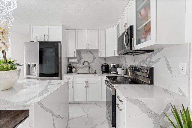4814 SW 20th St, Fort Lauderdale, FL 33317 - kitchen featuring a sink, decorative backsplash, white cabinetry, and stainless steel appliances