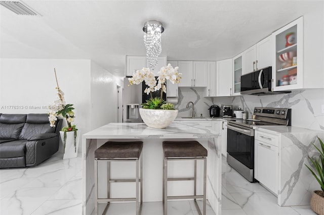 4814 SW 20th St, Fort Lauderdale, FL 33317 - kitchen featuring light stone countertops, visible vents, appliances with stainless steel finishes, marble finish floor, and a sink