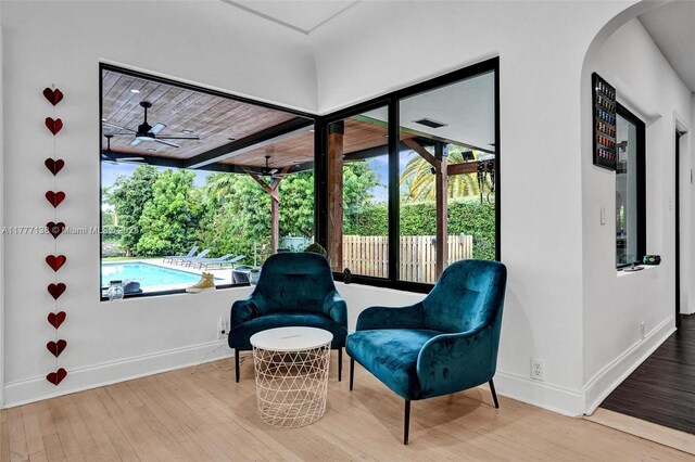 11060 Griffing Blvd, Biscayne Park, FL 33161 - sitting room featuring baseboards, arched walkways, ceiling fan, and wood finished floors