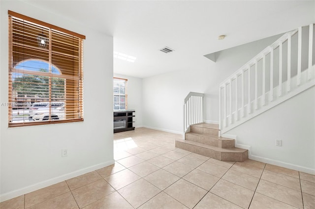 interior space with baseboards, stairs, and tile patterned flooring