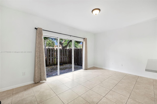 spare room with light tile patterned floors and baseboards