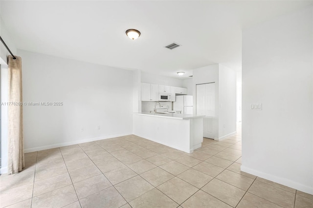unfurnished living room with baseboards, visible vents, and light tile patterned floors
