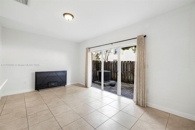 spare room featuring baseboards, visible vents, and tile patterned floors