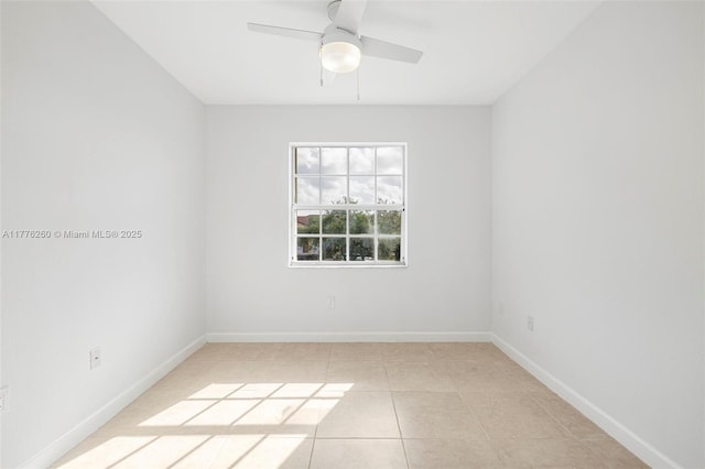 empty room with light tile patterned floors, baseboards, and a ceiling fan