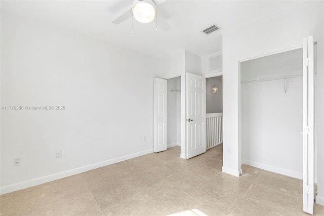 unfurnished bedroom with baseboards, visible vents, two closets, and ceiling fan