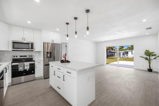 6335 Southgate Blvd, Margate, FL 33068 - kitchen featuring stainless steel appliances, modern cabinets, light wood-type flooring, light countertops, and hanging light fixtures
