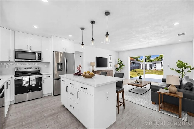 6335 Southgate Blvd, Margate, FL 33068 - kitchen with appliances with stainless steel finishes, open floor plan, a kitchen island, light countertops, and a breakfast bar area