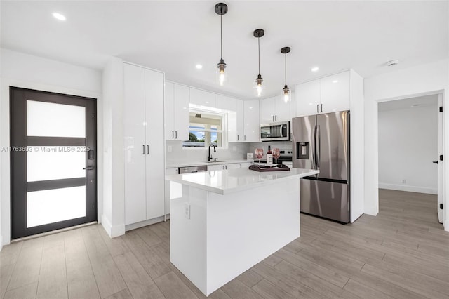 6335 Southgate Blvd, Margate, FL 33068 - kitchen featuring stainless steel appliances, a sink, white cabinets, light countertops, and a center island