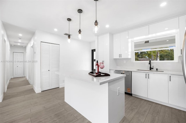 6335 Southgate Blvd, Margate, FL 33068 - kitchen with dishwasher, a sink, recessed lighting, light wood-type flooring, and white cabinets