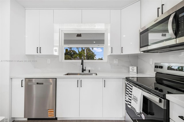 6335 Southgate Blvd, Margate, FL 33068 - kitchen with stainless steel appliances, a sink, white cabinetry, and decorative backsplash