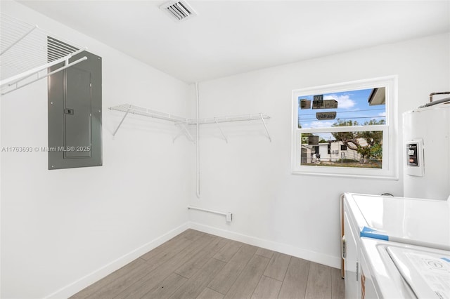 6335 Southgate Blvd, Margate, FL 33068 - clothes washing area with water heater, separate washer and dryer, baseboards, light wood-type flooring, and electric panel