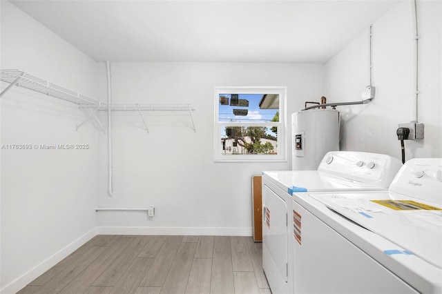 6335 Southgate Blvd, Margate, FL 33068 - laundry area with electric water heater, independent washer and dryer, light wood finished floors, and baseboards