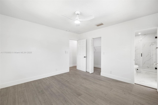 6335 Southgate Blvd, Margate, FL 33068 - unfurnished bedroom featuring baseboards, wood finished floors, a closet, a walk in closet, and connected bathroom