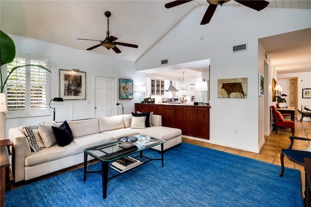 living room featuring high vaulted ceiling, visible vents, baseboards, a ceiling fan, and light tile patterned floors