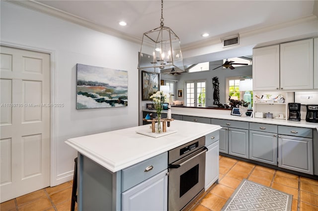 kitchen with visible vents, ornamental molding, a ceiling fan, stainless steel oven, and gray cabinets
