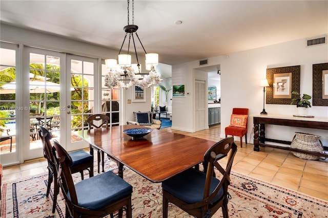 dining space with an inviting chandelier, light tile patterned flooring, french doors, and visible vents