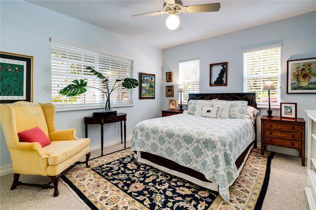 bedroom featuring light colored carpet, ceiling fan, and baseboards