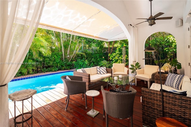 wooden terrace with an outdoor hangout area, a fenced backyard, a ceiling fan, and an outdoor pool