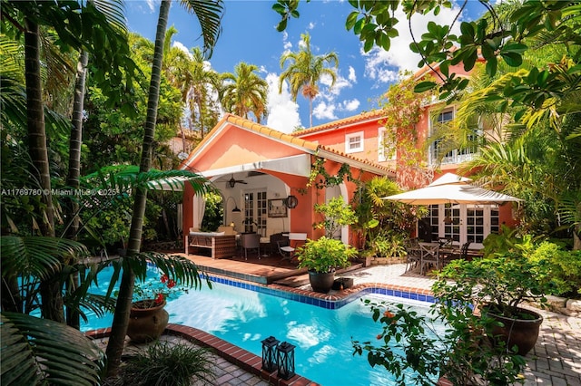 outdoor pool featuring outdoor dining space, ceiling fan, french doors, and a patio