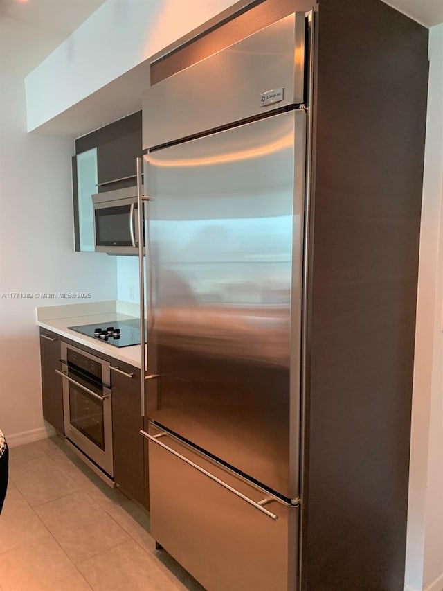 55 SE 6th St Unit 2404, Miami, FL 33131 - kitchen featuring light tile patterned floors, baseboards, appliances with stainless steel finishes, and light countertops